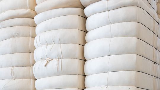Cotton bales placed on each other in a mill storage - click on the link to see the webinar recording about raw material management